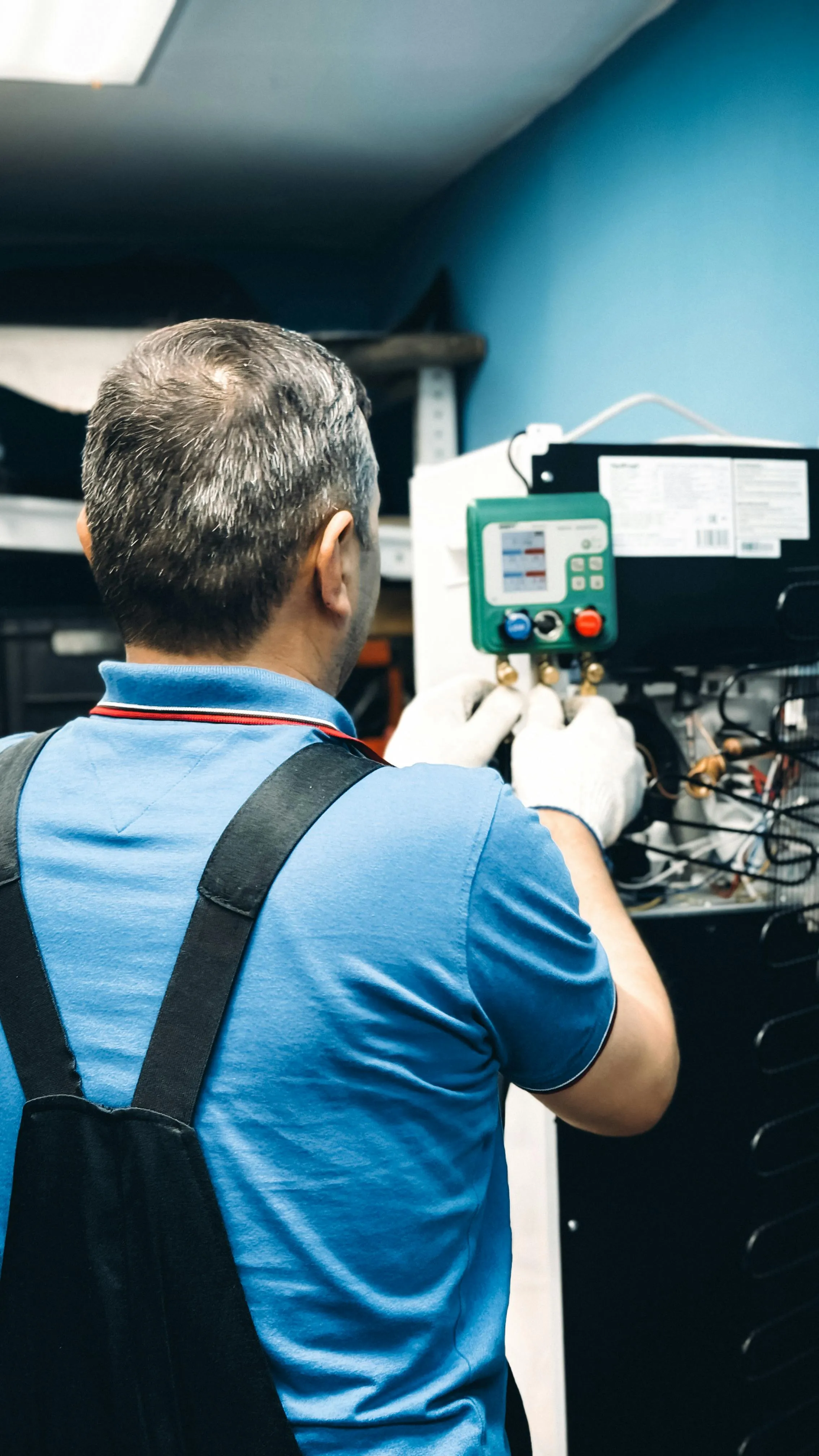 Engineer working with refrigerant manifold gauges during a heat pump installation